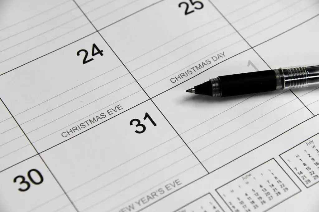 close-up of a calendar showing December 24 (Christmas Eve), December 25 (Christmas Day), and December 31 with a black pen resting on it